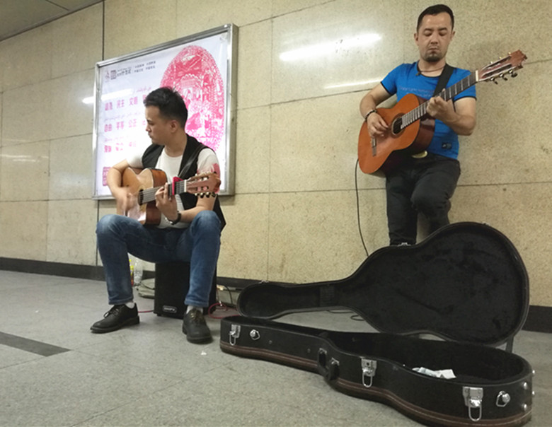 乌鲁木齐两帅哥弹吉他用音乐给市民送凉爽
