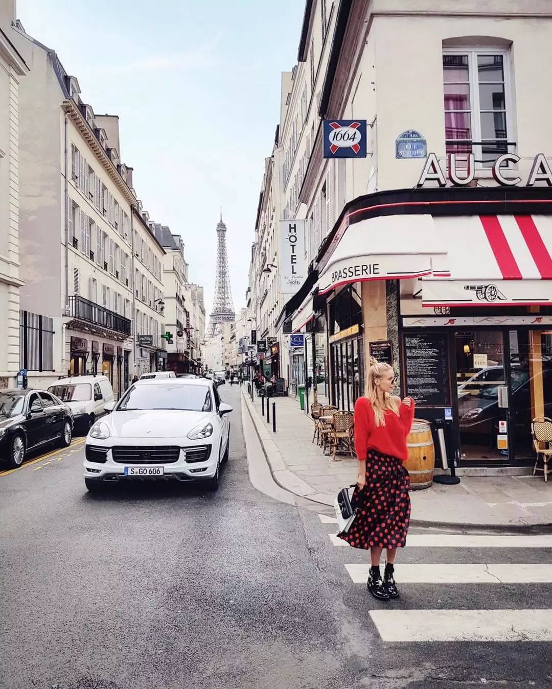 巴黎街头最尾端若隐若现埃菲尔铁塔的身影,街的另一头是用红色点亮这