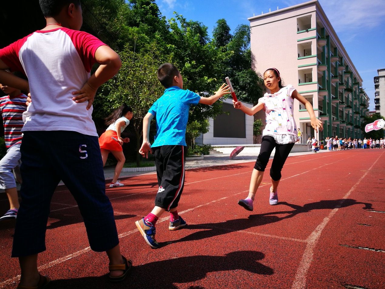 (金鸡小学的学生在进行50 米迎面接力跑比赛)