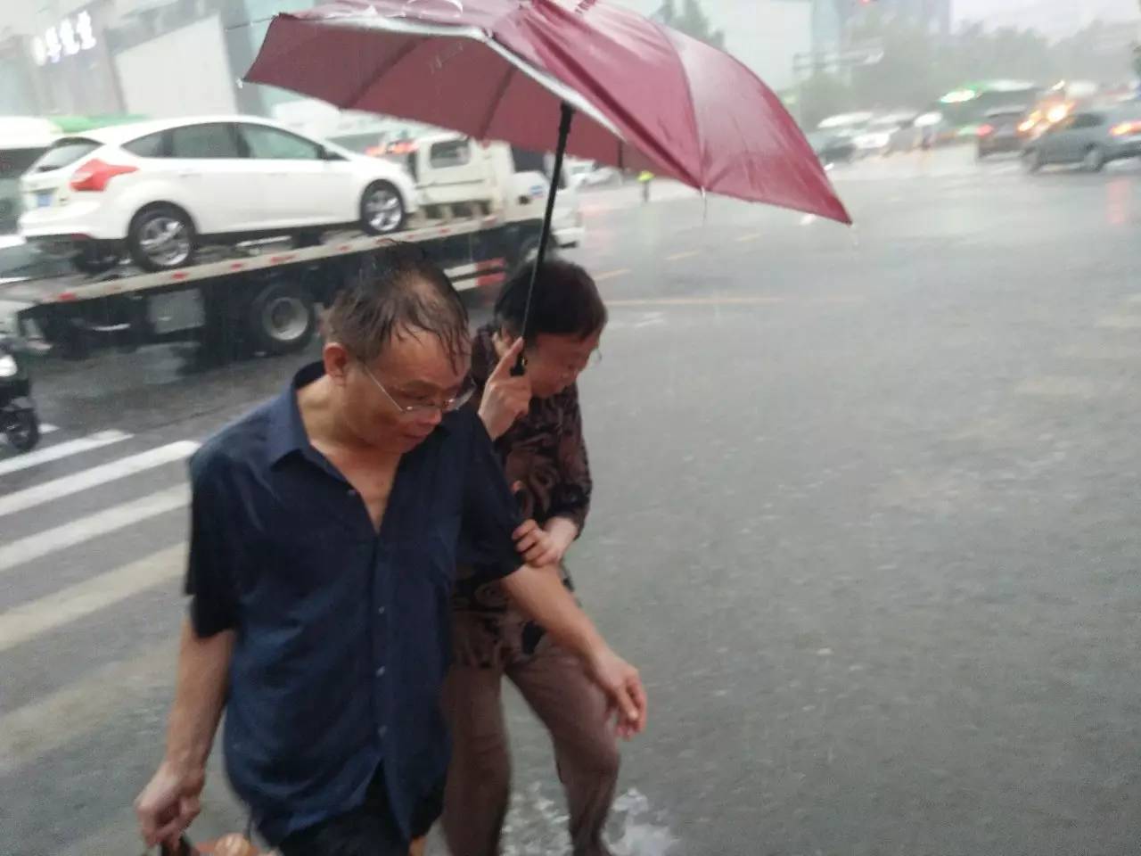 说明:雨中,两位老人相互搀扶回家.