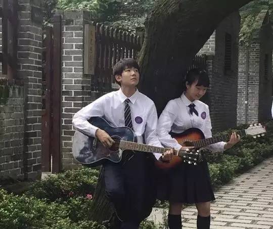 重庆南开中学的校服是 白衬衫搭配黑西裤黑裙 奶源怀抱吉他为母校拍摄