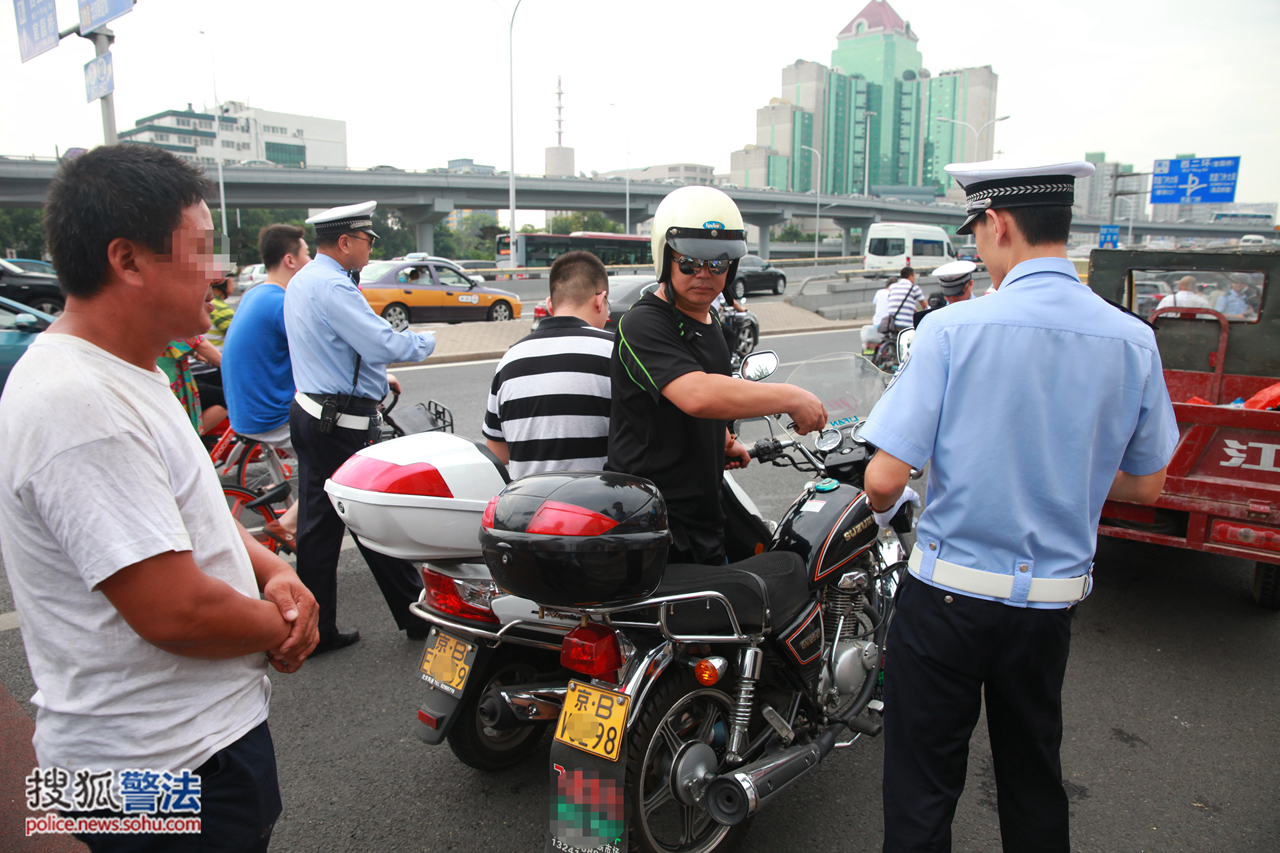 京b号牌摩托车在西直门桥区被民警拦下处罚