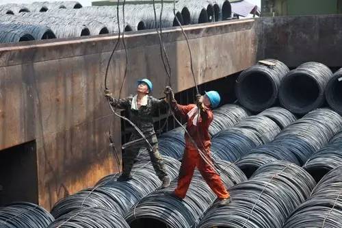 集装箱码头的工人,在闷热的船舱里挂摘钢丝绳钩.