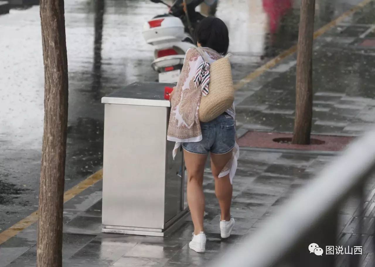 山西临汾:雨中捡垃圾的美女