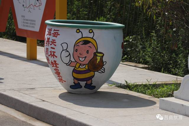 一个绘着小蜜蜂的大缸摆放在路边,这么萌的小蜜蜂还做起了蜂蜜广告,有