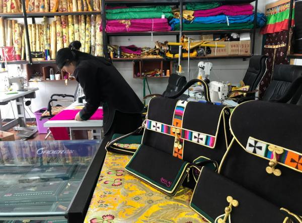 拉龙村氆氇缝制合作社里,工人正在手工制作藏族服装配饰
