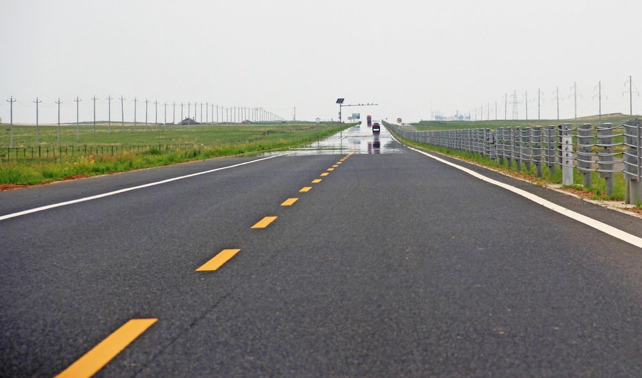 草原公路起起伏伏伸向远方,放眼望去,远处公路上却仿佛有飘渺的水面