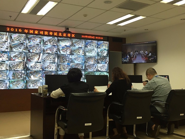 在国家司法考试北京考区指挥中心内,工作人员查看考场监控