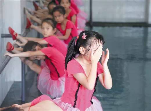 一个参加舞蹈兴趣班的女孩在练习压腿时痛得哭起来!
