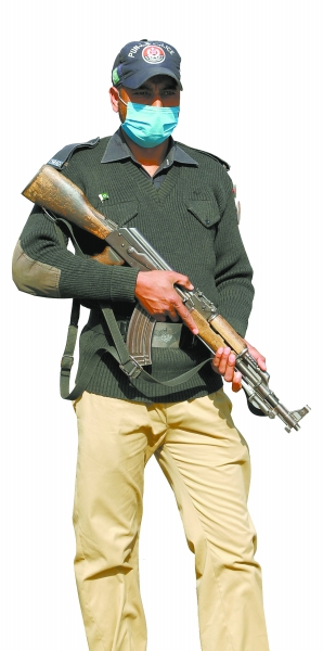 图为一名巴基斯坦警察在一处检查站持枪警戒新华社发