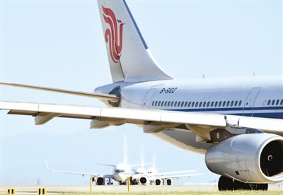 圖為飛機在北京首都機場中跑道上等候起飛.