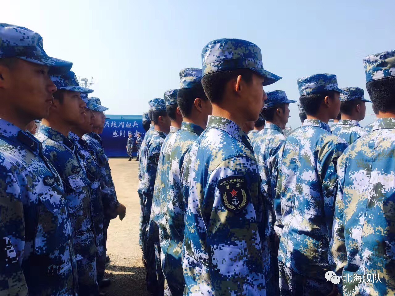 100余名新兵代表,身着海洋迷彩作训服,整齐地站在海军博物馆的码头上