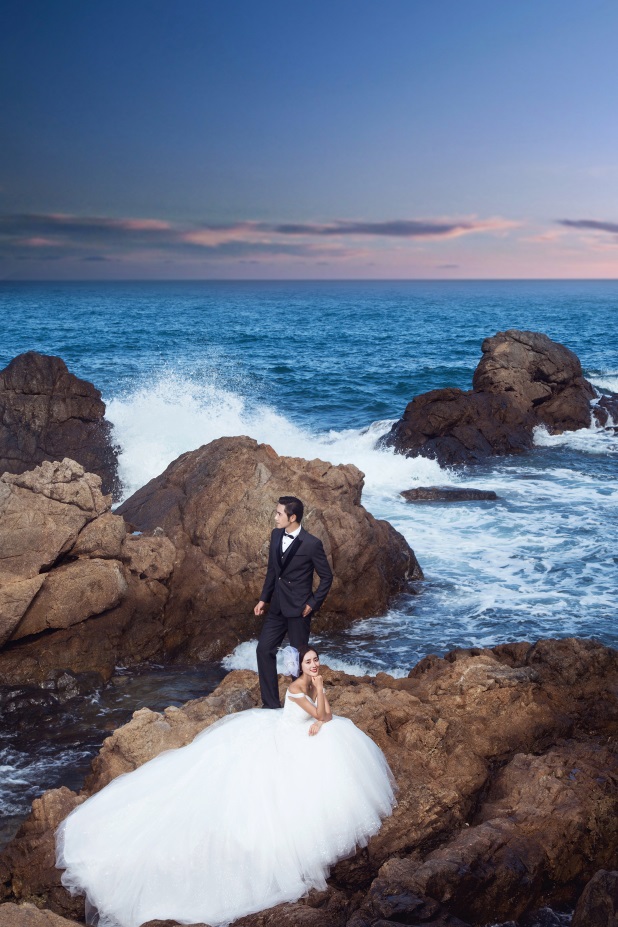 白色婚纱搭配上唯美大气的海景礁石拍出的海景婚纱照效果是非常受欢迎
