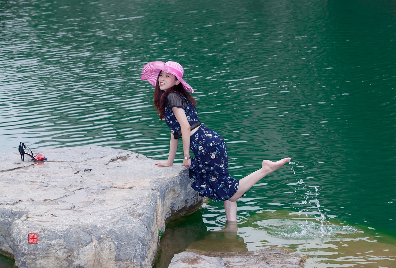 在风景秀丽清澈的河水边拍照的花裙美女姑娘!