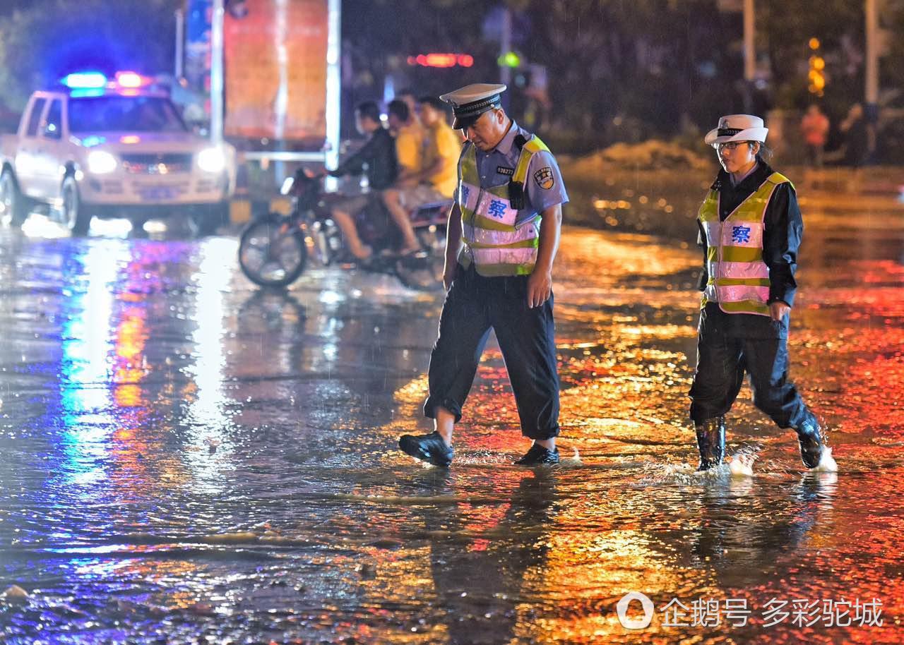 在雨中指挥交通的交警在路中央处理路面障碍交警焦急地指挥着交通暴雨